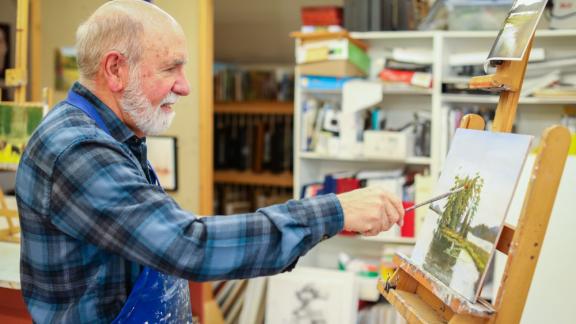man painting a landscape