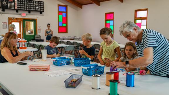 woman helping children with crafts