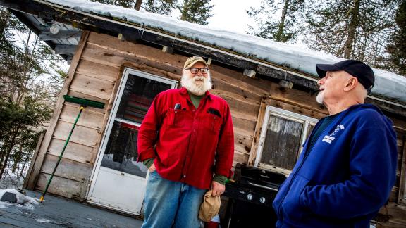 two men in front of cabin