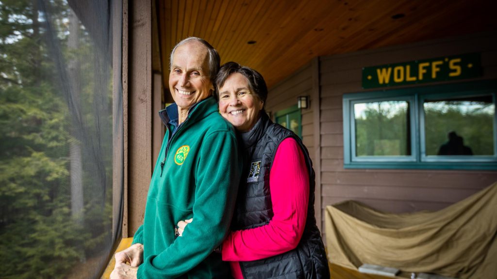 Couple stands together on a screened-in porch