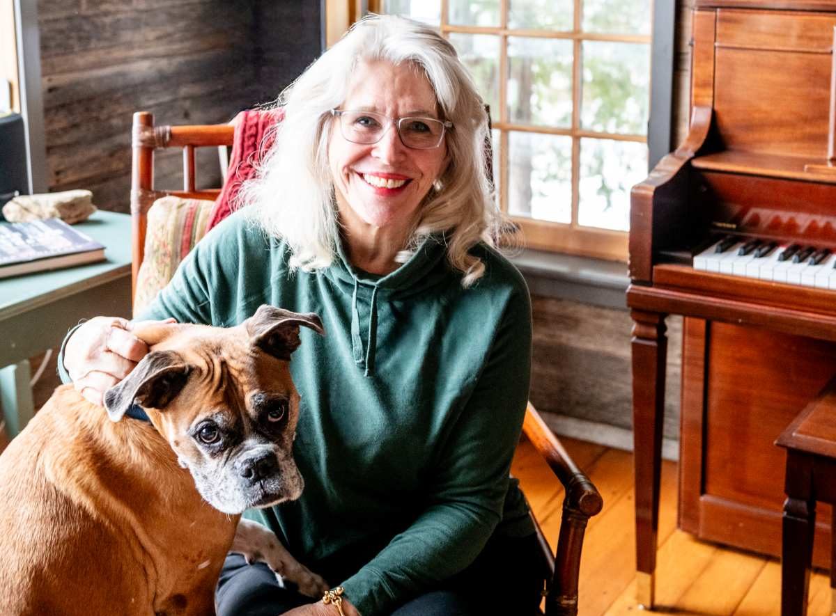 Woman poses for photo with her dog inside.