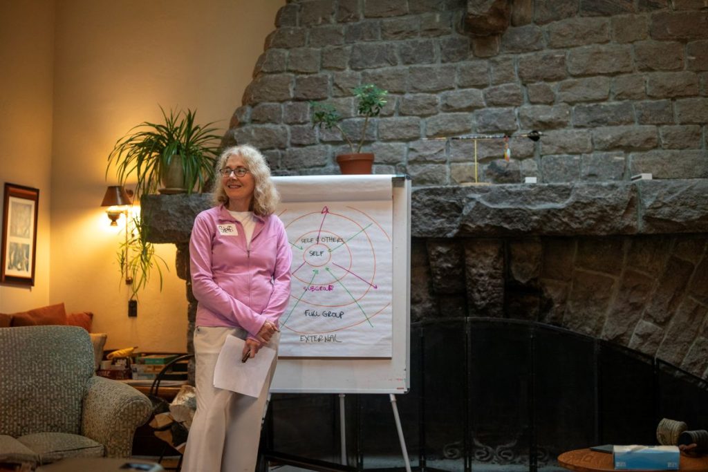 Woman stands in front of chimney presenting on a poster board