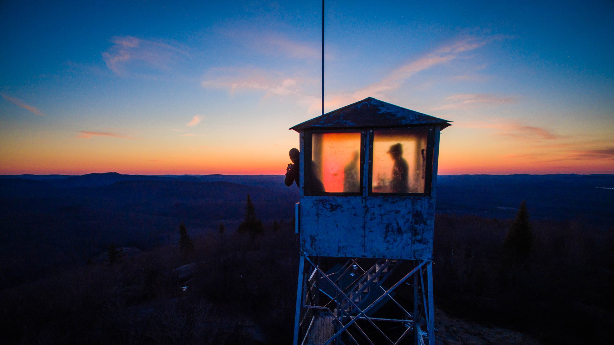 Fire tower silhoutted by sunset