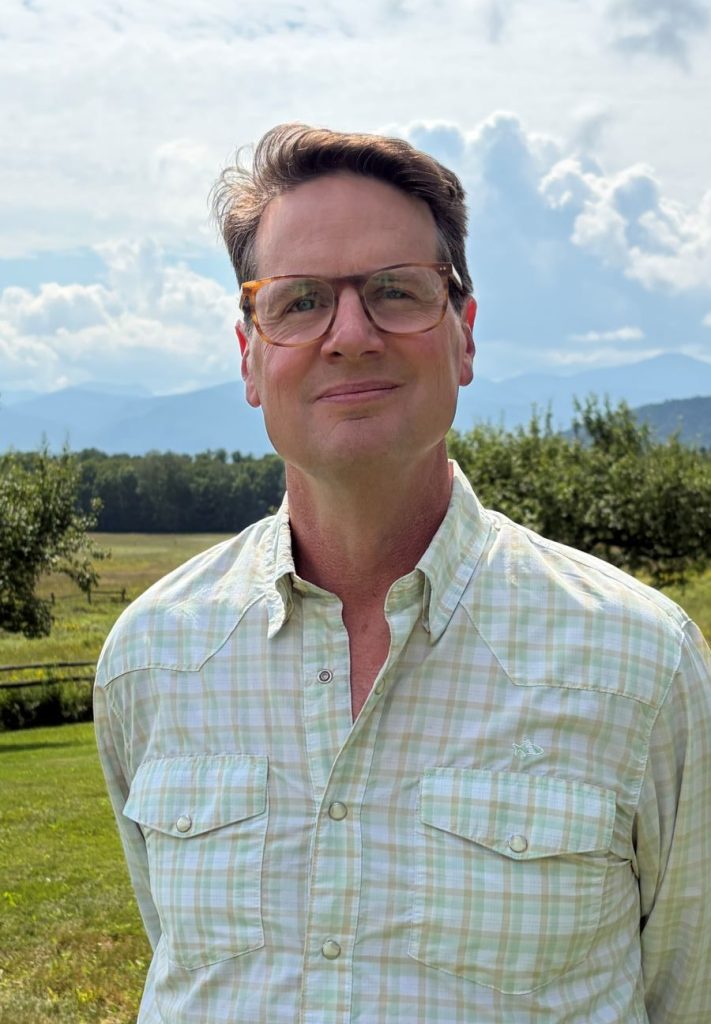 man posing in front of mountain scene